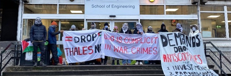 Photo of activists picketing the Rankine engineering building, holding banners and a Palestinian flag.